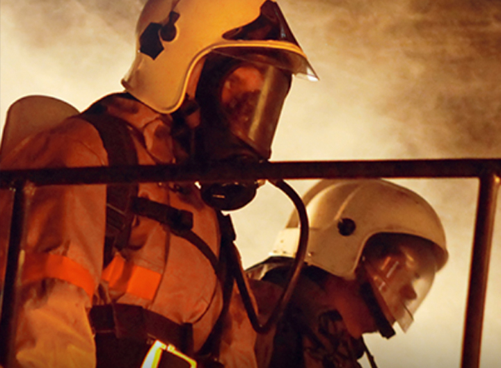 Stone Mountain photo of two people in full fire fighter outfit, smokey background is visible