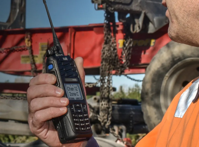 User holding a black Tait TP9500 DMR portable radio